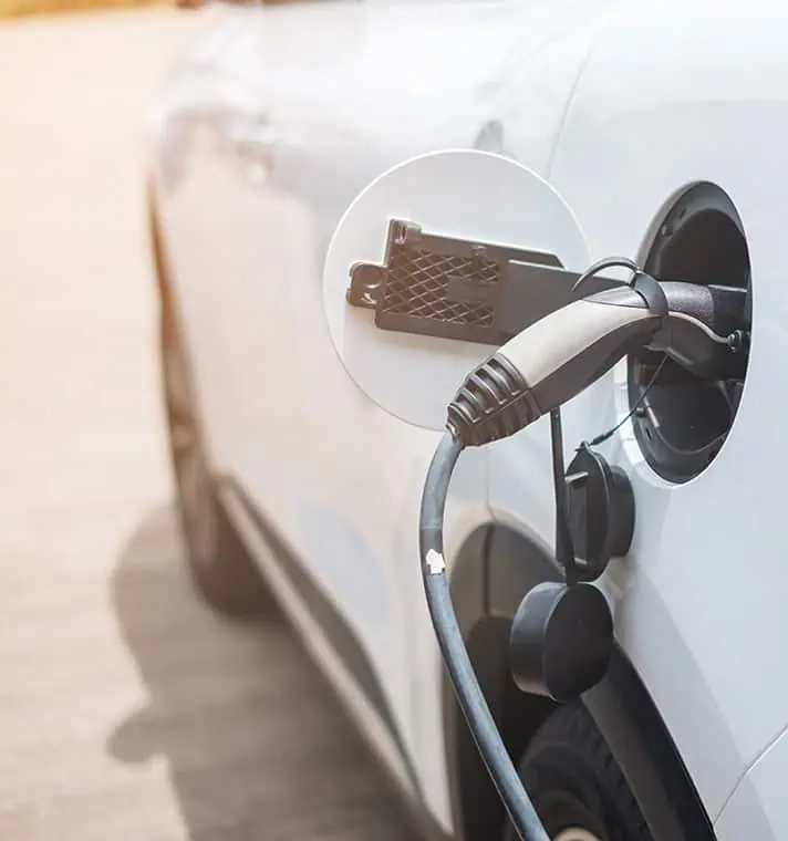 Home EV charger mounted on a wall beside a driveway
