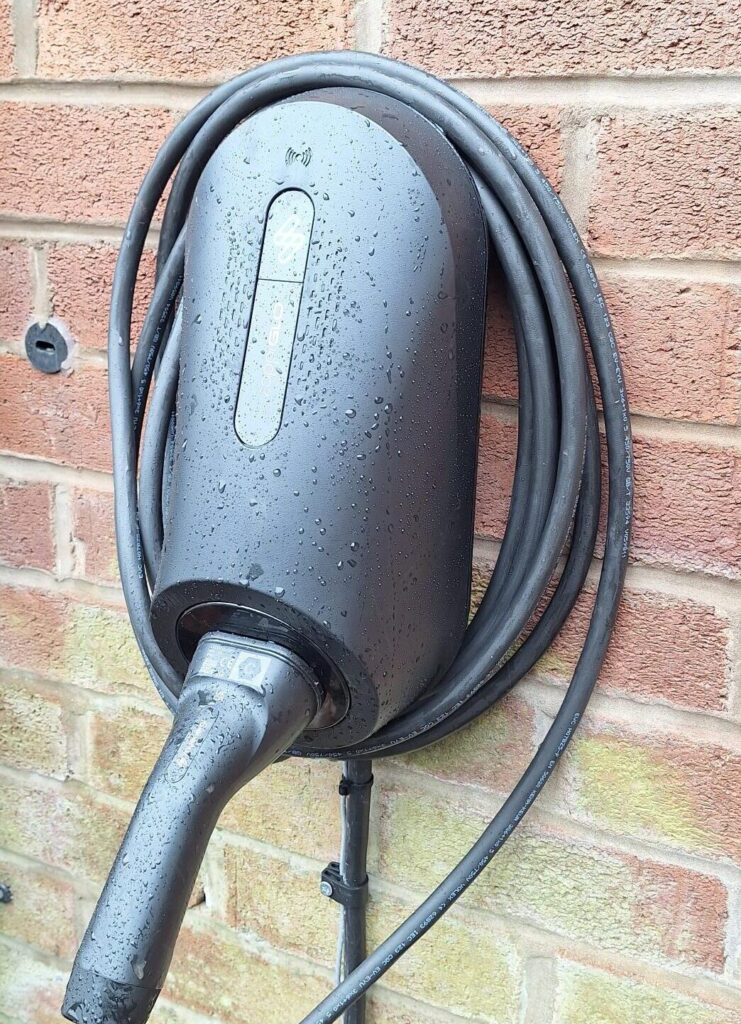 Electric vehicle charging point mounted on brick wall